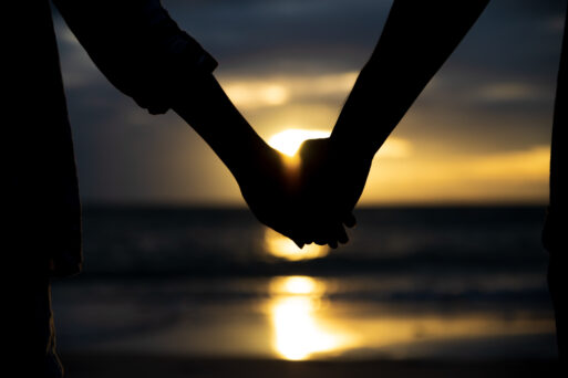 Symbols of love. silhouette Couple of man and woman hand holding together on sea and sky background during sunset for friendship day, love and valentines day concept
любовь